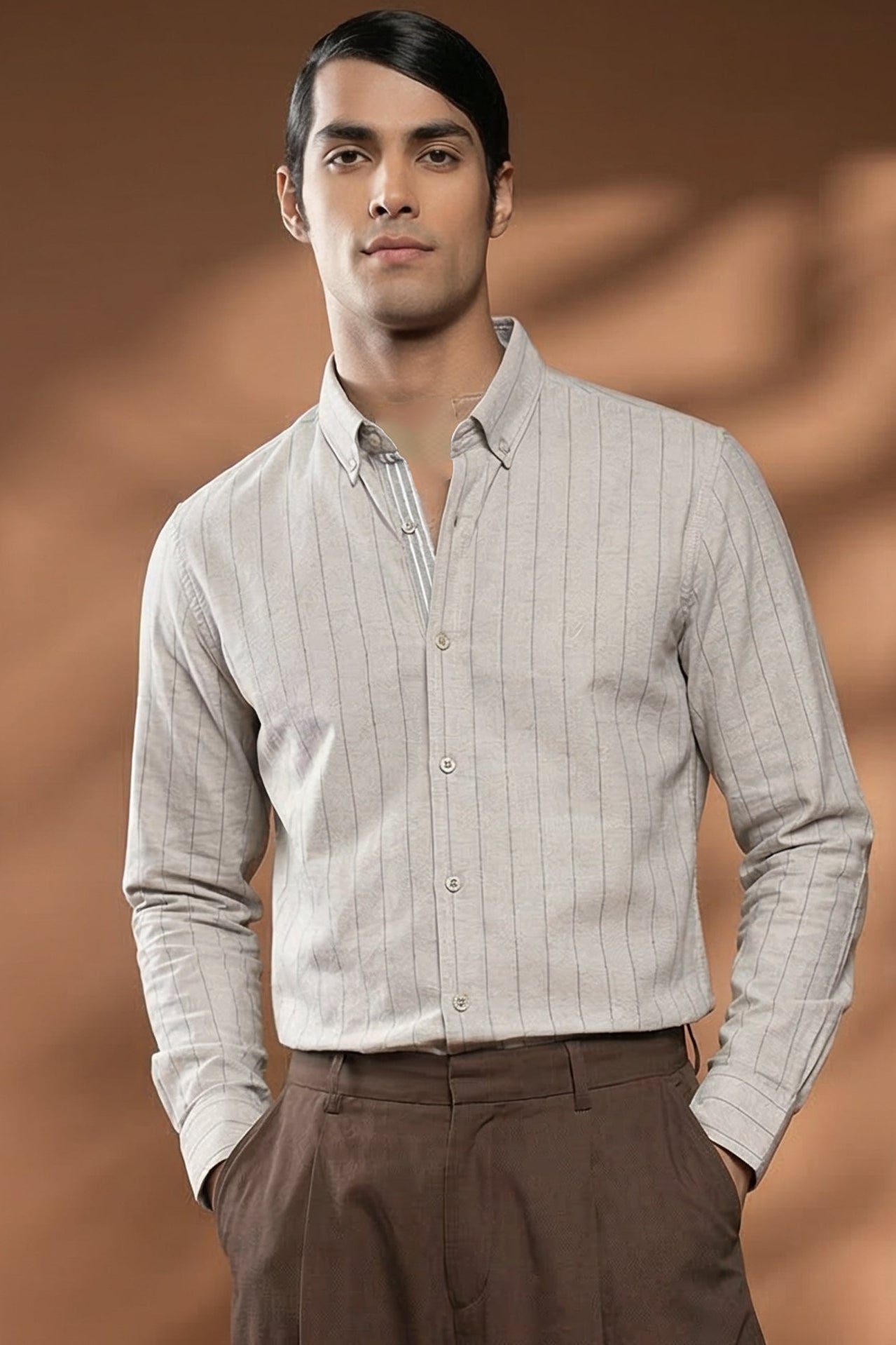 Man wearing a light-colored shirt and brown pants against a brown background with 'Surfing' text.